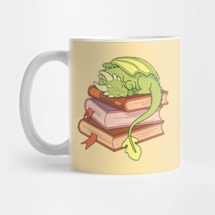 Little green dragon sleeping on a stack of books Mug